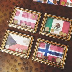 four framed pictures with different flags and coins in them on top of a wooden table