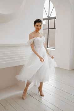 a woman in a white dress posing for the camera