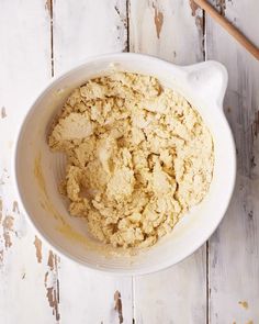 a white bowl filled with food on top of a wooden table