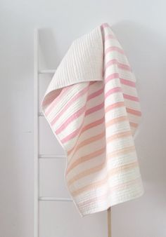 a pink and white striped towel hanging on a wall