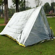 an upside down tent sitting in the grass