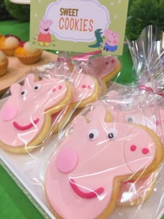 decorated cookies in the shape of peppa pig on display at a children's birthday party