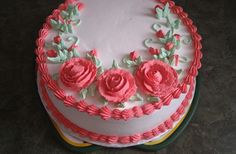 a white cake with pink frosting roses on it