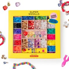 a box with lots of beads and bracelets in it on a white surface next to other items