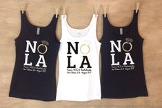 three women's tank tops hanging on clothesline with nola written across them