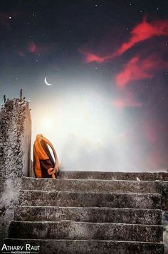 a person sitting on some steps under a night sky with the moon in the distance