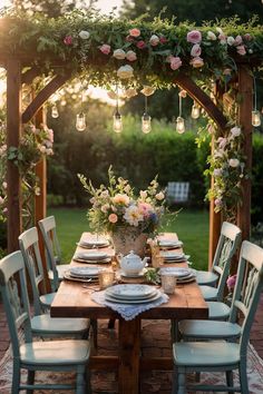 a wooden table topped with white plates and flowers