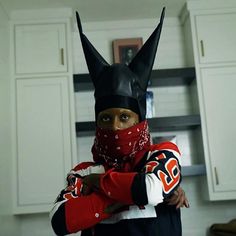 a person wearing a batman costume in a kitchen with his arms wrapped around the head