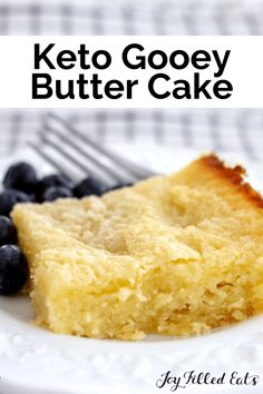 a piece of keto gooey butter cake on a white plate with blueberries