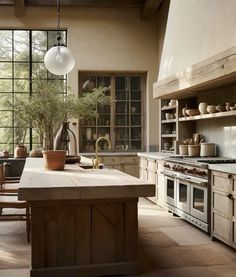 a large kitchen with an island in the middle and lots of pots on top of it