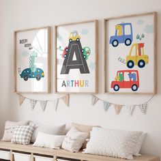 three framed children's pictures hang on the wall next to a bench with pillows