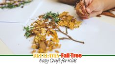 a child is playing with leaves on the paper and making a fall tree craft for kids