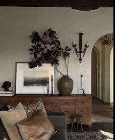 a living room filled with furniture and a potted plant on top of a table