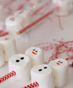 marshmallows with snowmen on them sitting next to candy canes