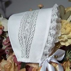 a white towel with lace on it sitting next to flowers