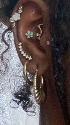 a close up of a person's ear with different types of piercings on it