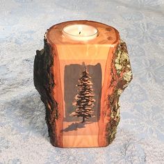 a wooden candle holder with a pine tree on it