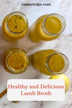 four jars filled with healthy and delicious lamb broth on top of a marble counter