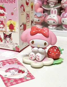 a hello kitty figurine sitting on top of a table next to a box