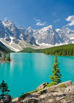 a scenic view of the canadian mountains and lake with blue water in front of it