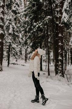 a woman standing in the snow with her hat on