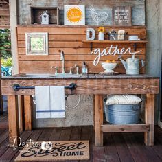 a rustic outdoor kitchen with wood paneling and white towels hanging on the rack above the sink