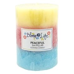 a candle that has been colored in different colors and is sitting on a white surface