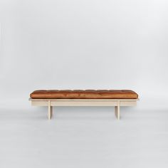 a wooden bench sitting on top of a white floor