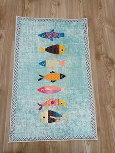 a rug with fish on it sitting on top of a wooden floor