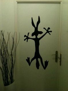 a door with a black silhouette of a person jumping up and holding two hands in the air