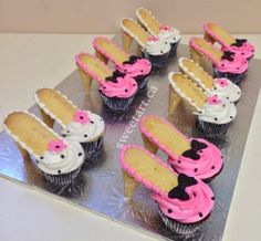 cupcakes with pink and white frosting are arranged on a silver platter