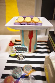 a table topped with lots of pastries on top of a white tray next to a knife and fork