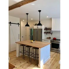 a kitchen with an island and three stools