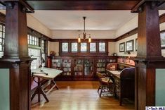 a room with wooden floors and lots of bookshelves in the middle of it