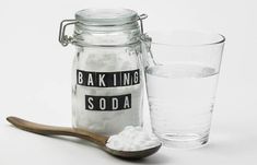 a glass and spoon with baking soda next to it