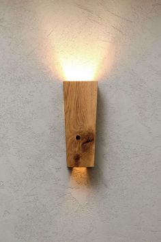 a light that is on the side of a wall with a wooden block attached to it