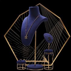 a blue and gold display case with jewelry on it's sides, in front of a black background