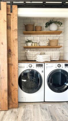 a washer and dryer in a room with open shelving on the wall