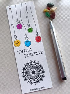 a pen and some candy sitting on top of a table next to a card with the words think positive