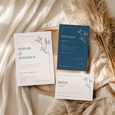 the wedding stationery is laid out on a bed with some dried grass and flowers