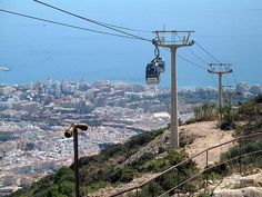 the cable car is going up the mountain to the top of the hill in the city