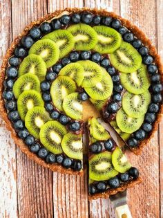 a pie with kiwis and blueberries on it