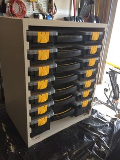 there are many yellow and black tools in the storage compartment on this workbench