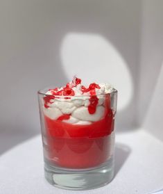 a red and white dessert in a glass on a table