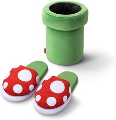 a pair of slippers sitting next to a green container with white polka dots on it