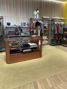 a clothing store with clothes on display and other items in the shop flooring area