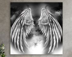 an artistic black and white photo with angel wings in the clouds on a grey background