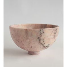 a marbled bowl on a wooden stand against a white background