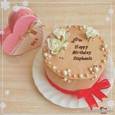 a birthday cake on a plate next to a heart shaped box