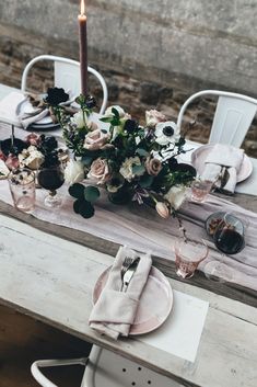 the table is set with flowers, candles and napkins for an elegant dinner party